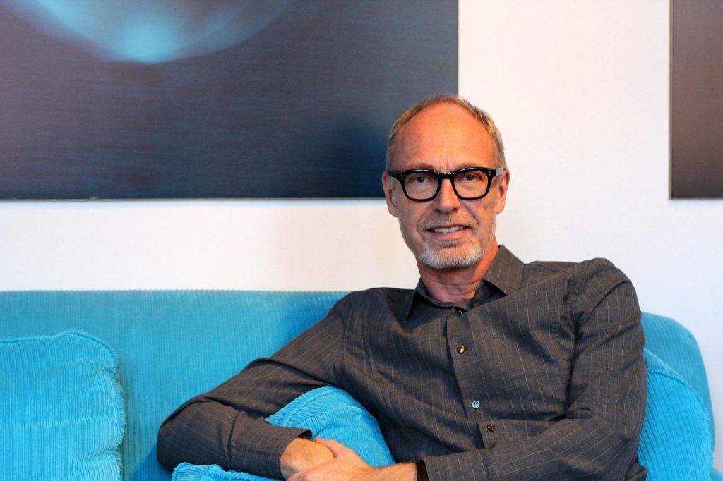 Preben Engelbrekt, direktør Børn, unge og sorg sidder i sort skjorte i turkis sofa